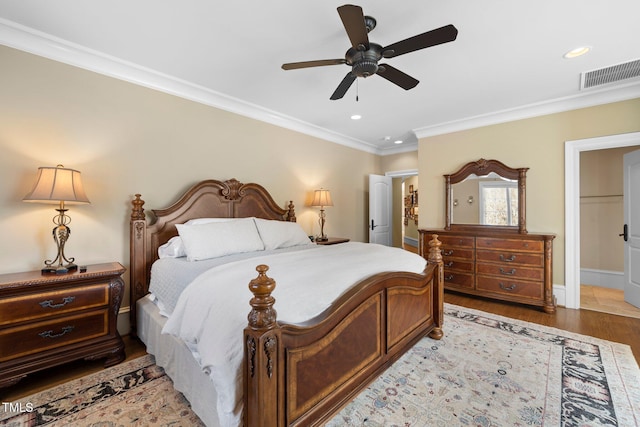 bedroom featuring connected bathroom, crown molding, light wood-type flooring, a closet, and ceiling fan