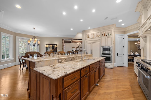 kitchen featuring a breakfast bar, sink, built in appliances, pendant lighting, and a large island