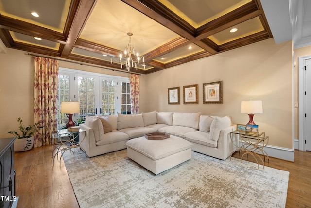 living room with coffered ceiling, crown molding, a chandelier, light hardwood / wood-style flooring, and beam ceiling