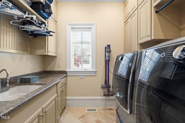 laundry room featuring cabinets, sink, light tile patterned floors, and washing machine and clothes dryer