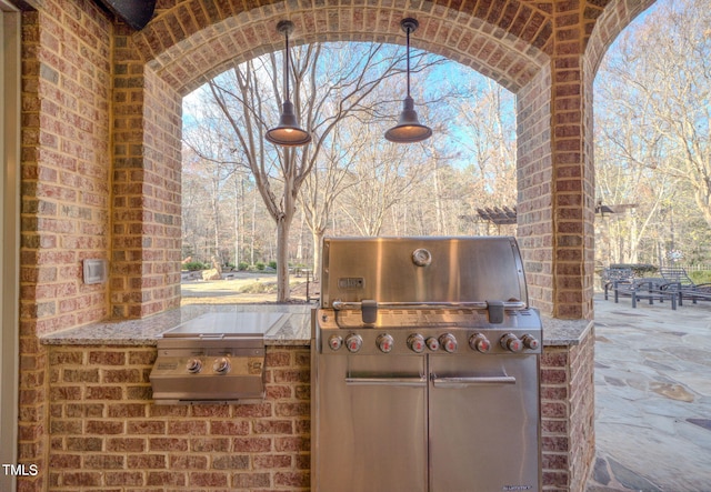 view of patio / terrace featuring an outdoor kitchen and a grill