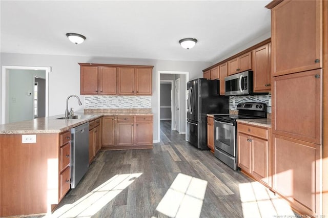 kitchen featuring stainless steel appliances, dark hardwood / wood-style floors, sink, and backsplash