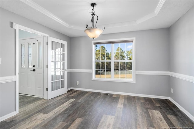 unfurnished dining area with crown molding, a tray ceiling, and dark hardwood / wood-style floors