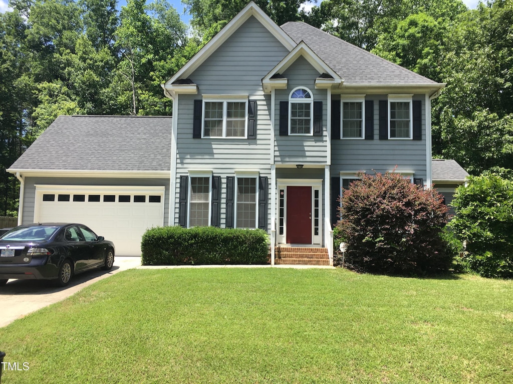 view of front of house with a garage and a front yard