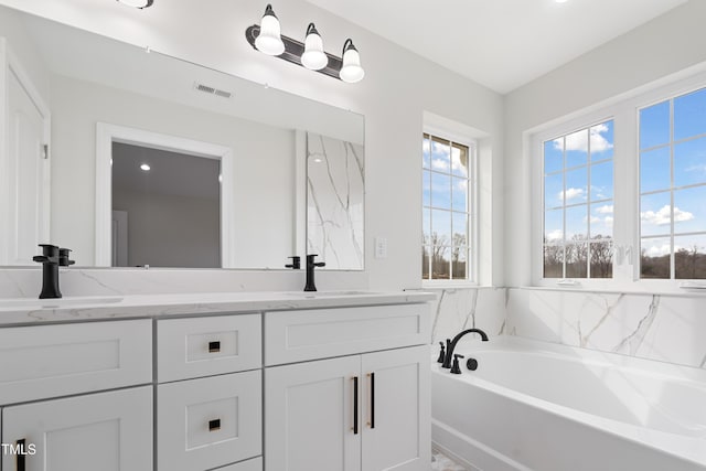 bathroom featuring vanity and a bath