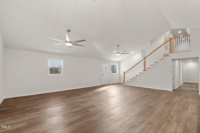 unfurnished living room featuring ceiling fan, a healthy amount of sunlight, and dark hardwood / wood-style flooring