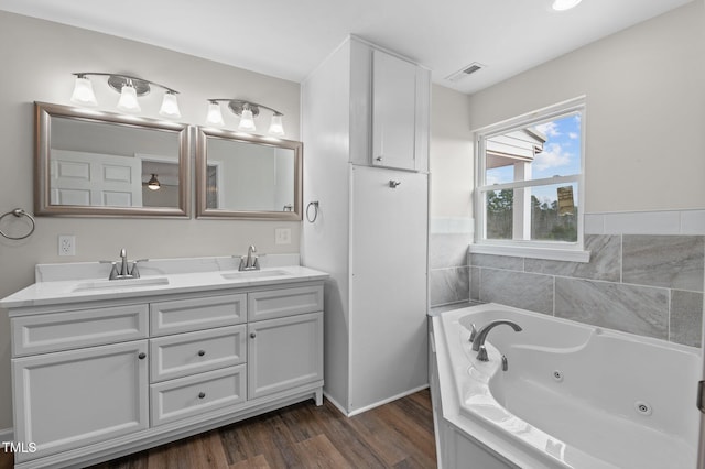 bathroom featuring a washtub, vanity, and hardwood / wood-style floors