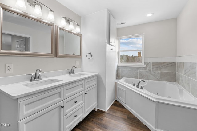 bathroom featuring vanity, wood-type flooring, and a tub