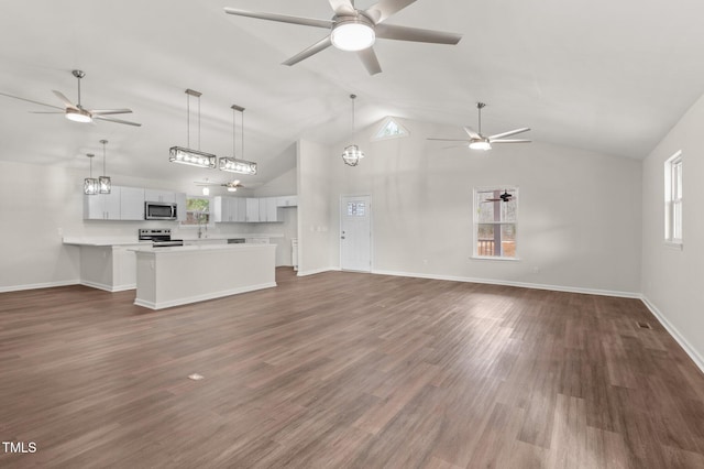 unfurnished living room with high vaulted ceiling, dark hardwood / wood-style floors, and ceiling fan with notable chandelier