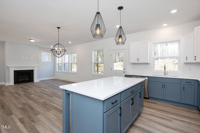 kitchen featuring pendant lighting, sink, tasteful backsplash, white cabinets, and stainless steel dishwasher