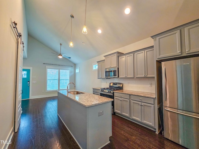 kitchen featuring sink, appliances with stainless steel finishes, gray cabinetry, light stone counters, and tasteful backsplash