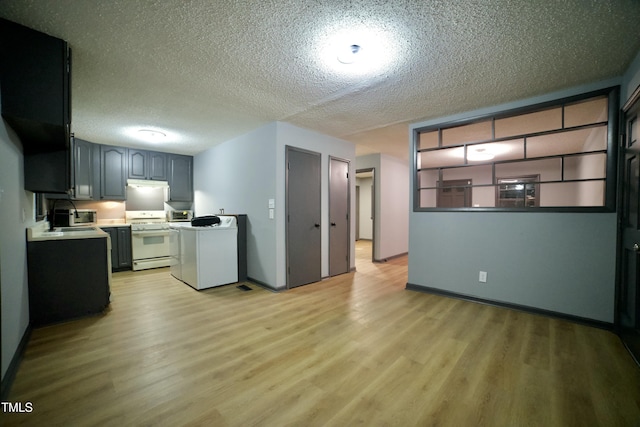 kitchen featuring washer / clothes dryer, gray cabinets, light wood-type flooring, and white stove