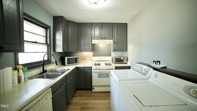 washroom featuring dark hardwood / wood-style flooring, sink, independent washer and dryer, and a textured ceiling