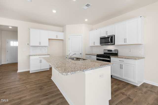 kitchen with a kitchen island with sink, sink, white cabinetry, and appliances with stainless steel finishes