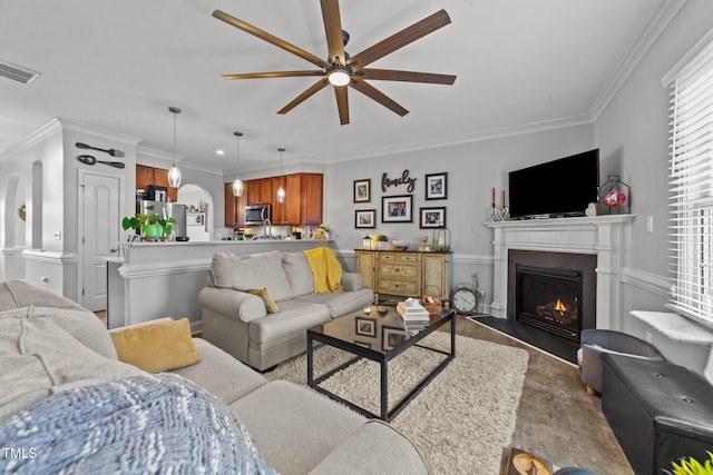 living room featuring ceiling fan and ornamental molding