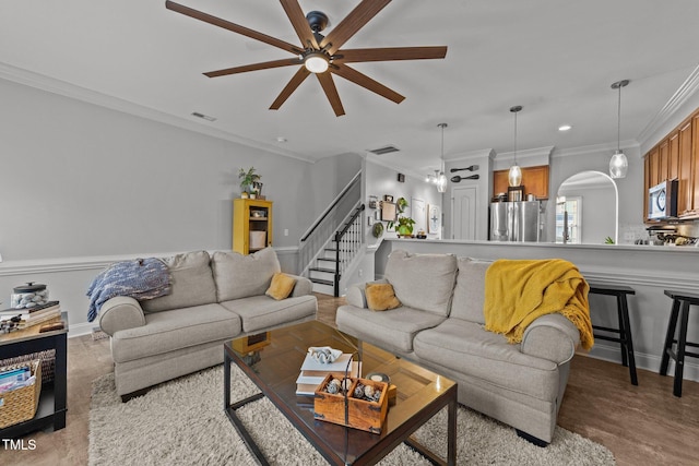 living room with crown molding and ceiling fan