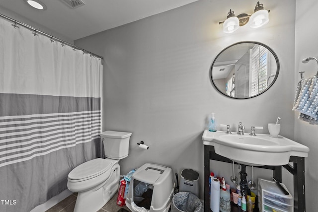 bathroom with sink, a shower with shower curtain, and toilet