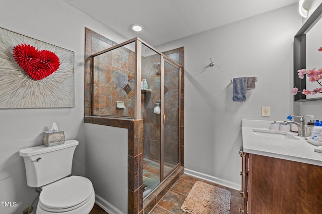 bathroom featuring toilet, vanity, and walk in shower