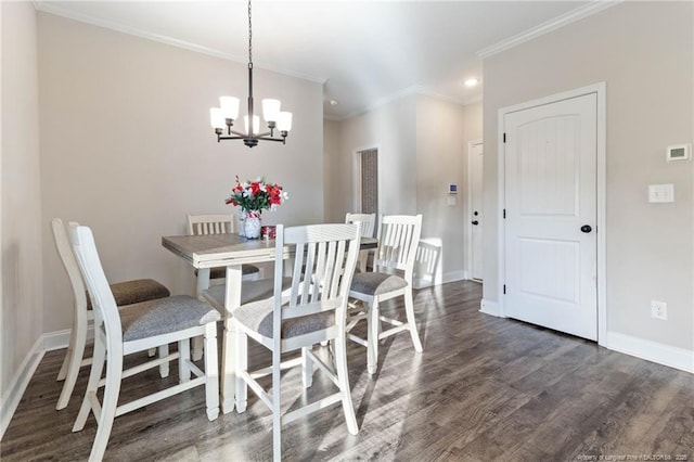 dining space featuring dark wood-type flooring, ornamental molding, and a notable chandelier