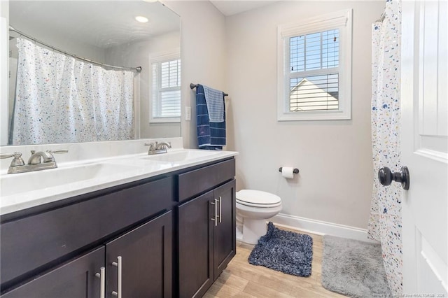 bathroom featuring wood-type flooring, vanity, and toilet