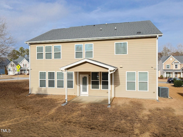 rear view of house with central AC and a patio area