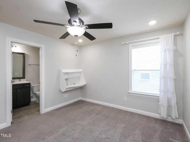 unfurnished bedroom with connected bathroom, light carpet, and ceiling fan