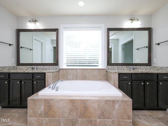 bathroom with vanity, tile patterned flooring, and tiled tub