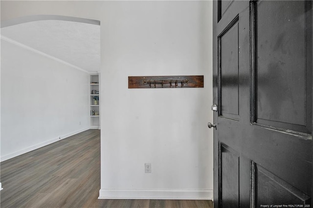 foyer entrance featuring crown molding and dark hardwood / wood-style floors