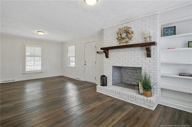 unfurnished living room featuring built in features, dark hardwood / wood-style flooring, a fireplace, and a textured ceiling