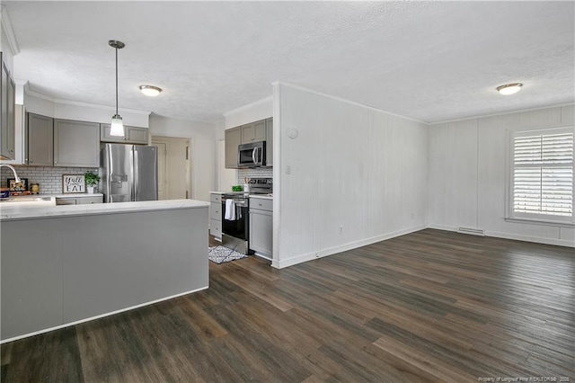 kitchen with appliances with stainless steel finishes, dark hardwood / wood-style floors, decorative light fixtures, sink, and gray cabinetry