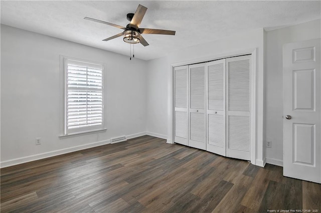 unfurnished bedroom with dark wood-type flooring, ceiling fan, and a closet