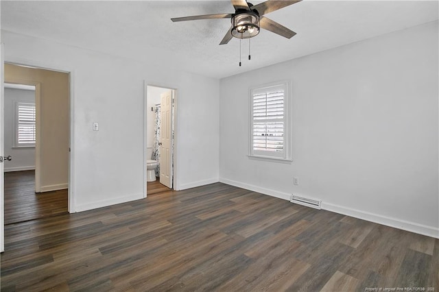 unfurnished bedroom featuring dark hardwood / wood-style flooring, ceiling fan, and ensuite bathroom