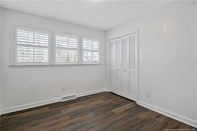 unfurnished bedroom with dark hardwood / wood-style floors and a closet