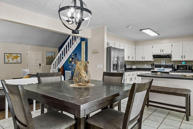 dining area featuring an inviting chandelier, radiator, a textured ceiling, and light tile patterned floors