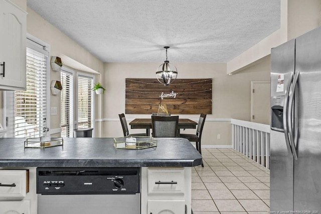 kitchen with white cabinetry, stainless steel appliances, a textured ceiling, light tile patterned flooring, and decorative light fixtures