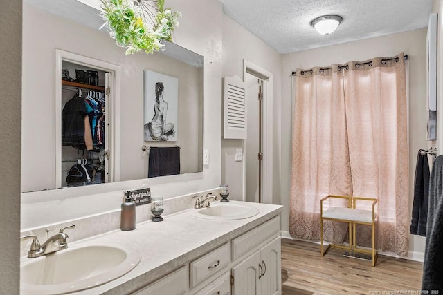 bathroom with hardwood / wood-style flooring, vanity, and a textured ceiling