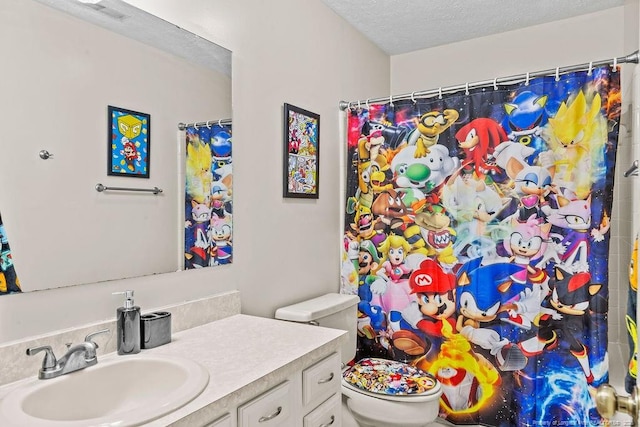 bathroom with vanity, toilet, curtained shower, and a textured ceiling