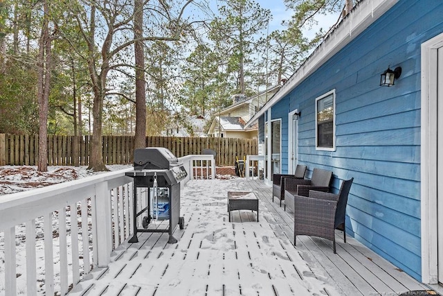 snow covered patio featuring a wooden deck and grilling area