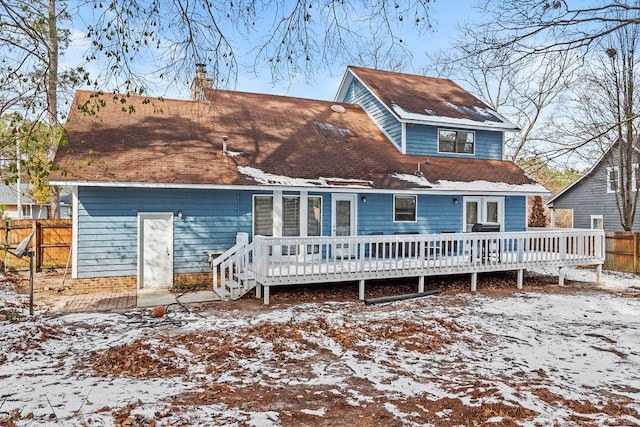 snow covered house with a wooden deck