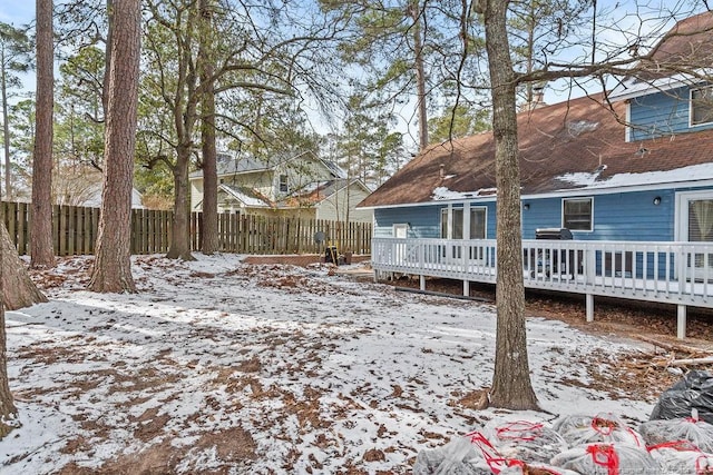 yard covered in snow featuring a wooden deck