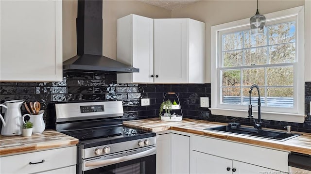 kitchen with white cabinets, wall chimney exhaust hood, sink, and electric range