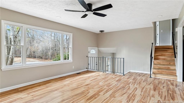 spare room featuring ceiling fan, a textured ceiling, and light hardwood / wood-style flooring