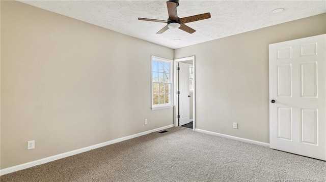 carpeted spare room featuring ceiling fan and a textured ceiling