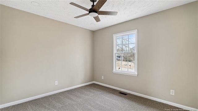 carpeted spare room featuring ceiling fan and a textured ceiling