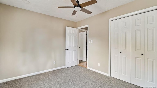 unfurnished bedroom featuring carpet flooring, ceiling fan, and a closet