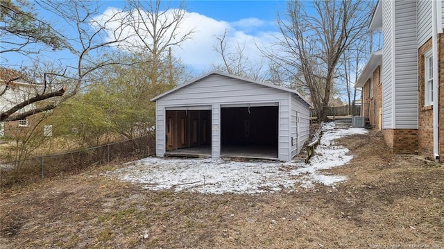 snow covered garage featuring central air condition unit