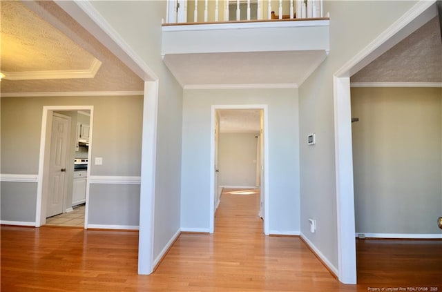 hallway with ornamental molding and light wood-type flooring