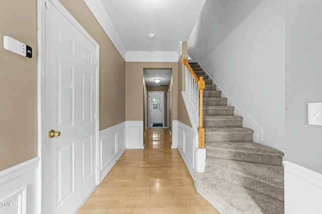 entrance foyer with crown molding and light wood-type flooring