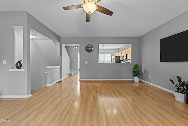 unfurnished living room with ceiling fan and light hardwood / wood-style flooring