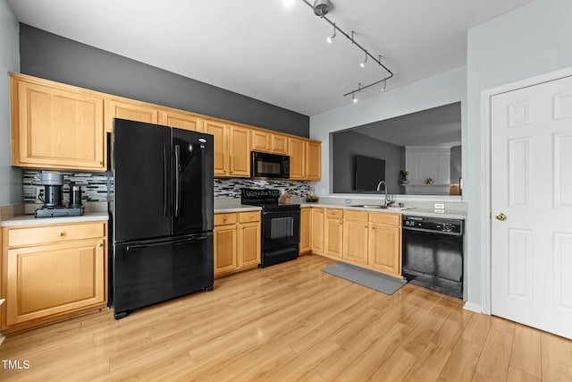 kitchen featuring sink, backsplash, light hardwood / wood-style floors, black appliances, and light brown cabinets